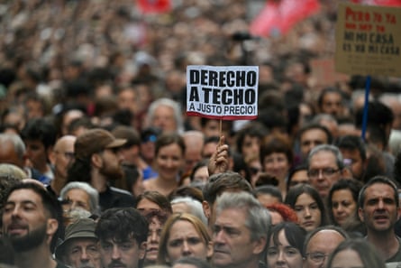 A demonstrator amid a huge crowd holds up a sign reading ‘Right to a Roof’