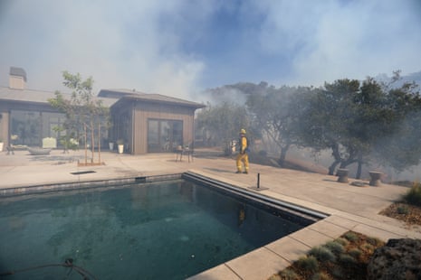 Firefighters work to defend homes from an approaching wildfire in Sonoma, California.