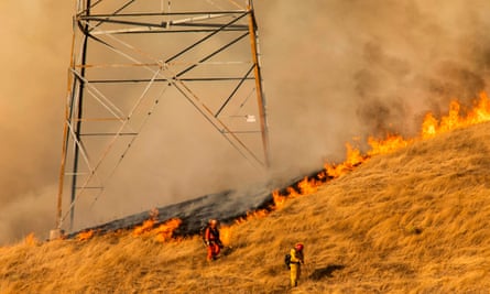 Firefighters set a back fire along a hillside near PG&amp;E power lines during firefighting operations to battle the Kincade fire.