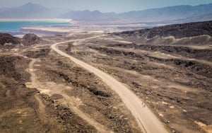 Three Ethiopian migrants walk along Djibouti’s coastal road north to Obock, past Lake Assal, one of the lowest and hottest places on earth.