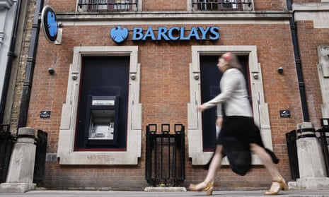 A pedestrian walks past a branch of British bank Barclays in central London