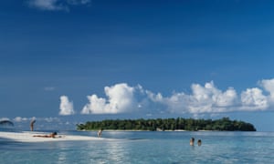 Tourist sunbathing and swimming in the Maldives.