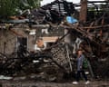 A woman walks in front of a house destroyed in a Russian strike on a residential neighbourhood in Kyiv