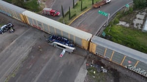 A drone view shows emergency workers around the remains of a doubledecker bus involved in a collision with a train