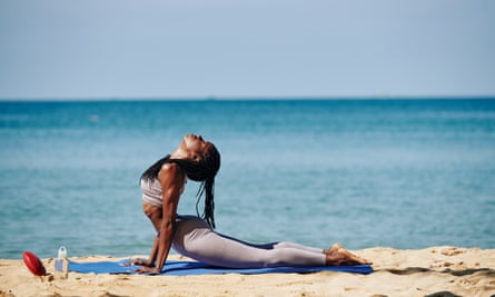 Young woman doing yoga on the beach