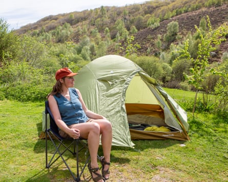 Sian Lewis sitting in a Montbell chair in front of a tent