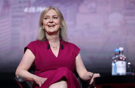 Liz Truss sits in a chair on stage at the Cpac conference in London.