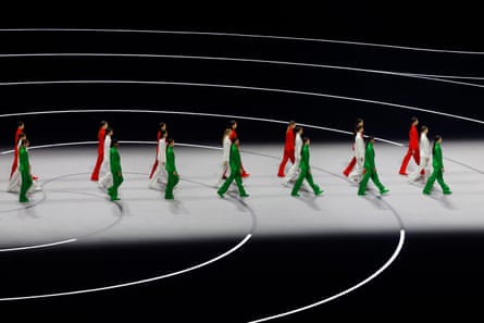 Three groups of models walk the runway wearing creations designed by Giorgio Armani