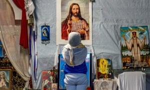 A refugee prays at the ‘Jungle’ camp in Calais on Christmas Day 2015