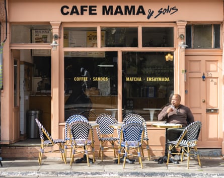 The owner of Mama & Sons sits in front of his cafe.