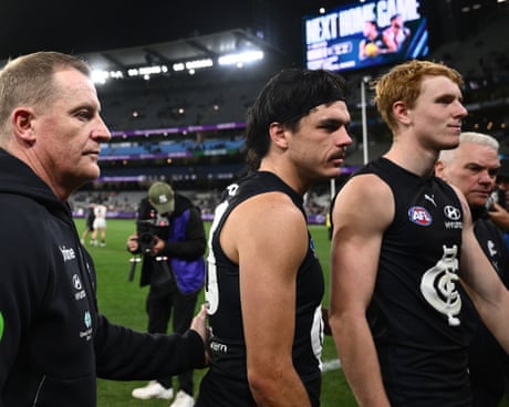 Carlton coach Michael Voss and player Elijah Hollands leaving the field at the MCG