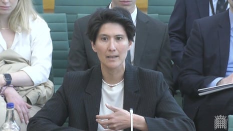 Cat Little sitting at a table with her name on it while being questioned