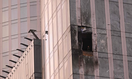 A woman inspects the damage after a drone hit a building in Moscow's business district