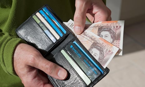 Close up of person taking £10  notes  from wallet