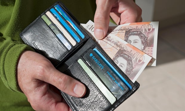 Close up of man person taking £10 notes English from wallet 