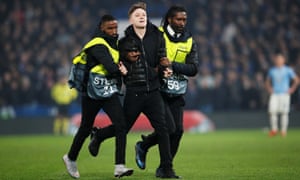 A pitch invader is escorted off.