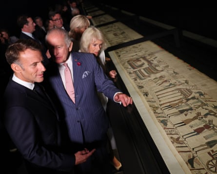 People look at a tapestry.