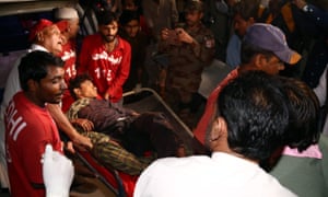 Medics carry a man who was injured in a bomb blast at a Shah Noorani shrine in Pakistan.