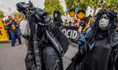 Extinction Rebellion activists in black protesting against Shell with Shell signs in background