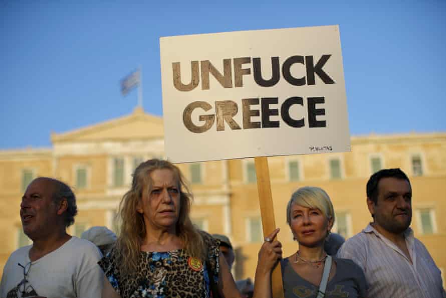 A protester holds a banner during a pro-government rally calling on Greece’s European and International Monetary creditors to soften their stance in the cash-for-reforms talks in Athens, June 17, 2015.The Greek central bank warned on Wednesday that the country risked a painful exit from the euro and ultimately even the European Union if Athens and its creditors do not strike a swift aid-for-reforms deal. REUTERS/Paul Hanna