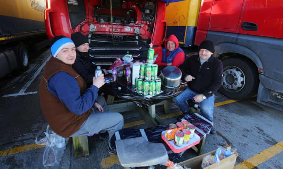 Polish lorry drivers, with a makeshift Christmas tree made out of empty Heineken cans, share Christmas Day food and drinks near Folkestone, Kent.