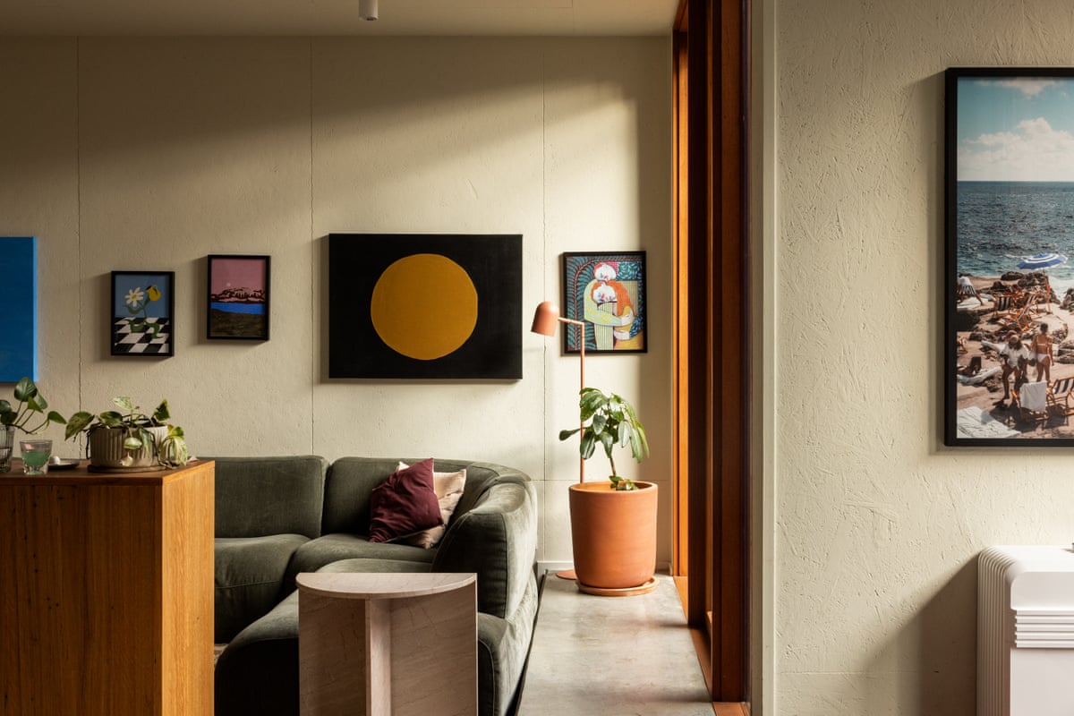 An interior shot of a townhouse living space with a couch, art on the walls and indoor plants
