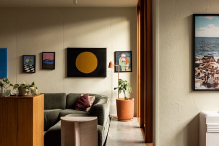 An interior shot of a townhouse living space with a couch, art on the walls and indoor plants