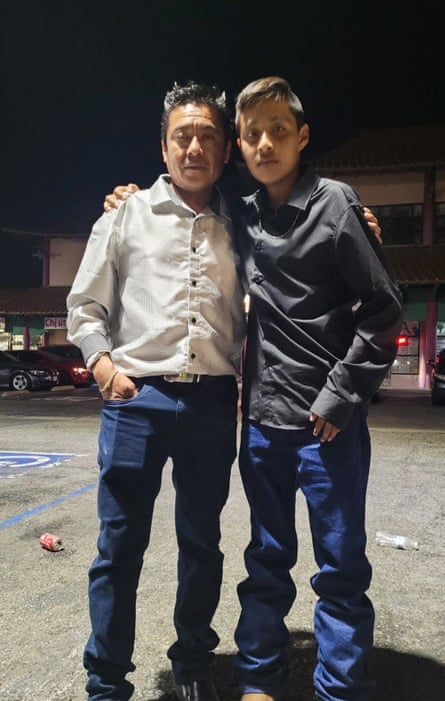 a father and son stand together for a photo
