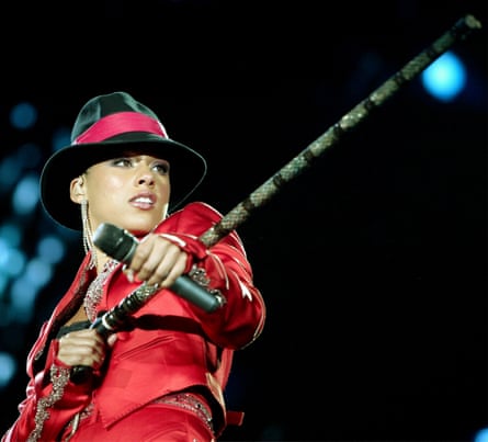 Keys on stage, wearing a red suit and black hat with a red band