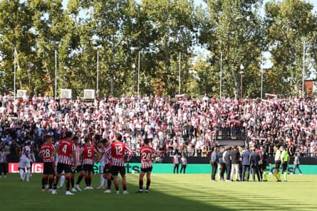 Athletic Club players wait on the pitch (left) as the referee makes the decision to abandon the La Liga match between Rayo Vallecano and Athletic Club (right).