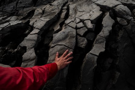 A person rests their hand on black earth