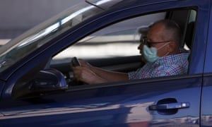 A man in car wearing a face mask to protect against coronavirus, waits at the Horgos border crossing into Hungary from Serbia, 180 kms north of Belgrade, Serbia, Wednesday, July 1, 2020.