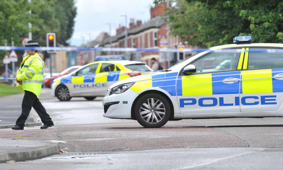 Police at the scene of the stabbing in Moss Side, Manchester