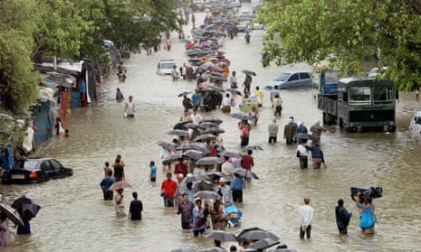 People walk on a flooded street after torrential rains paralysed Mumbai in July 2005.