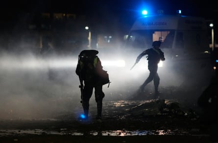 A police offer protects himself from teargas spread to disperse people from getting near the site of the crashed aircraft and its cargo of newly printed money in El Alto, Bolivia.