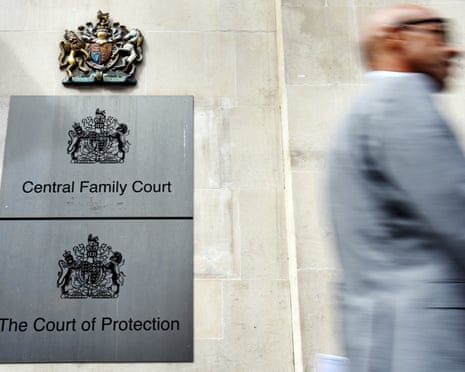 A man walks past signs for the central family court and the court of protection in London