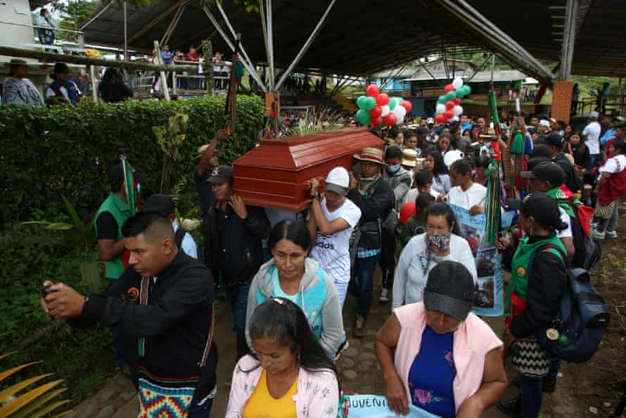 A procession follows people carrying a coffin