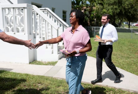 a woman extends her hand to shake another person’s hand
