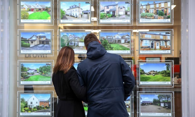 Would-be homebuyers peruse an estate agent’s window