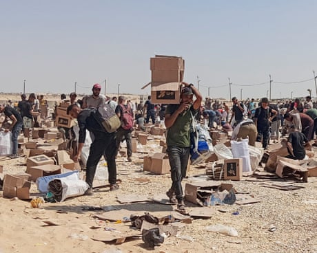 Palestinians collect the remains of relief supplies in Rafah