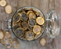 An open jar full of saved one-pound coins