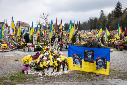 Brother Dong unfurls a flag with his compatriots who died in the Russia-Ukraine war