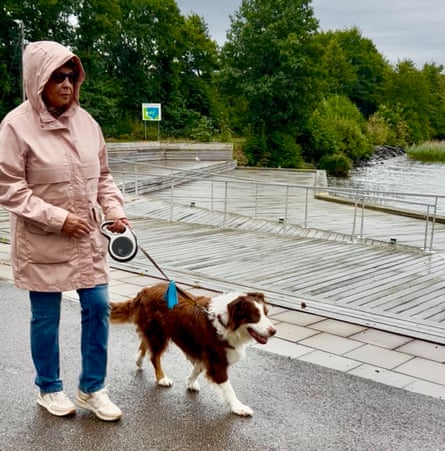 Joyce Thomas wearing a pink hooded coat and walking a dog in the rain Joyce Thomas wearing a pink hooded coat and walking a dog in the rain