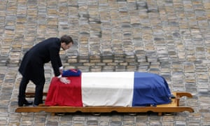 Emmanuel Macron touches the flag-draped coffin of Arnaud Beltrame, the gendarme who died after trading places with a woman during a hostage situation in Trèbes.