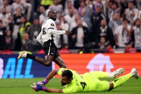 Ndidi celebrates scoring a goal, running past a goalkeeper lying on the pitch