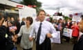 Tony Blair hand in hand with Cherie Blair smailing and greeting people at an outdoor capaign event