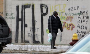 In a Dec. 12, 2008 file photo, a pedestrian walks by graffiti in downtown Detroit.