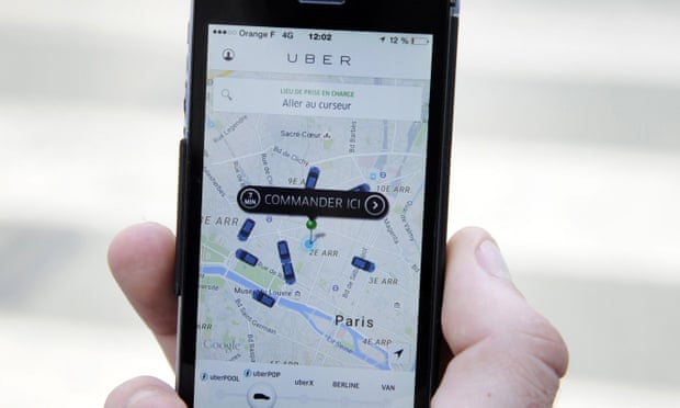 A person uses the French version of the Uber app to order a UberPop cab in Paris.