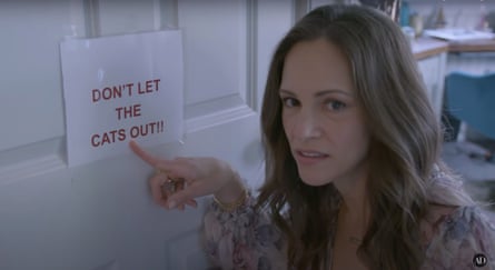 Susan Downey points to a laminated sign that reads: don't let the cats out