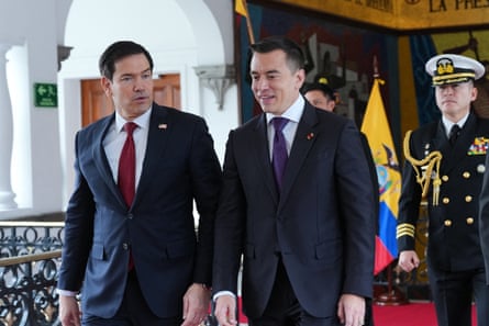 Two middle aged men in suits speak as they walk, with a man in military uniform behind them. Two middle aged men in suits speak as they walk, with a man in military uniform behind them.